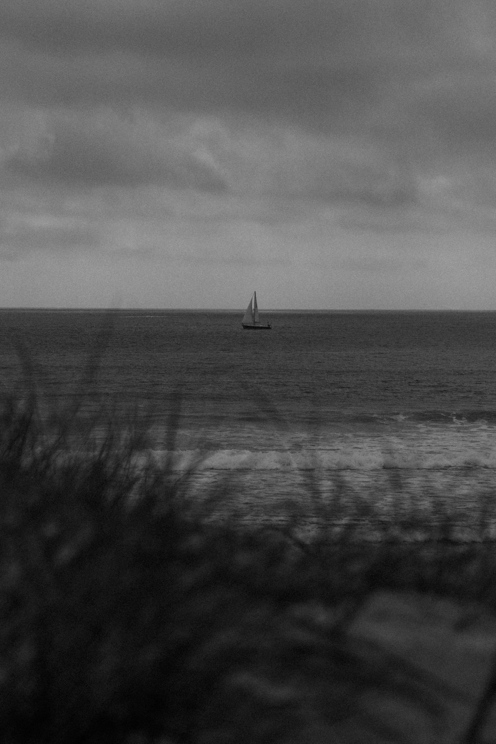 a black and white photo of a boat in the ocean