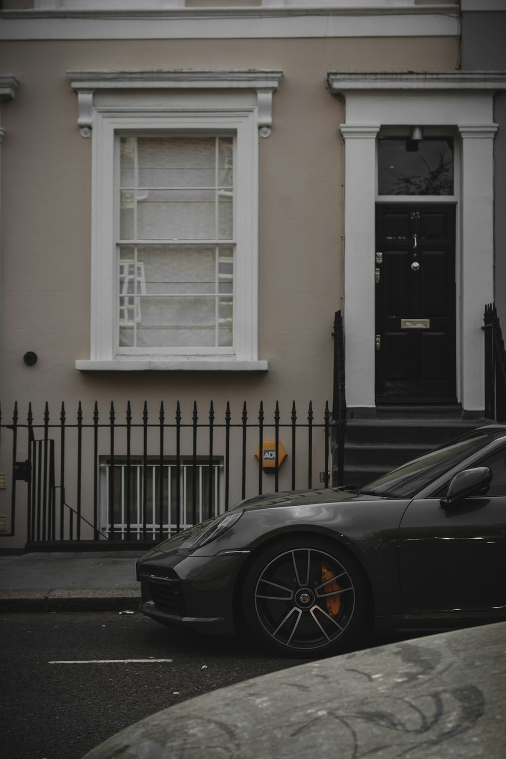 a black sports car parked in front of a house