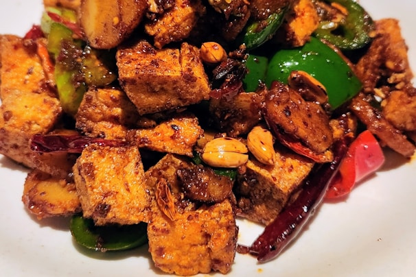 a white plate topped with tofu and peppers