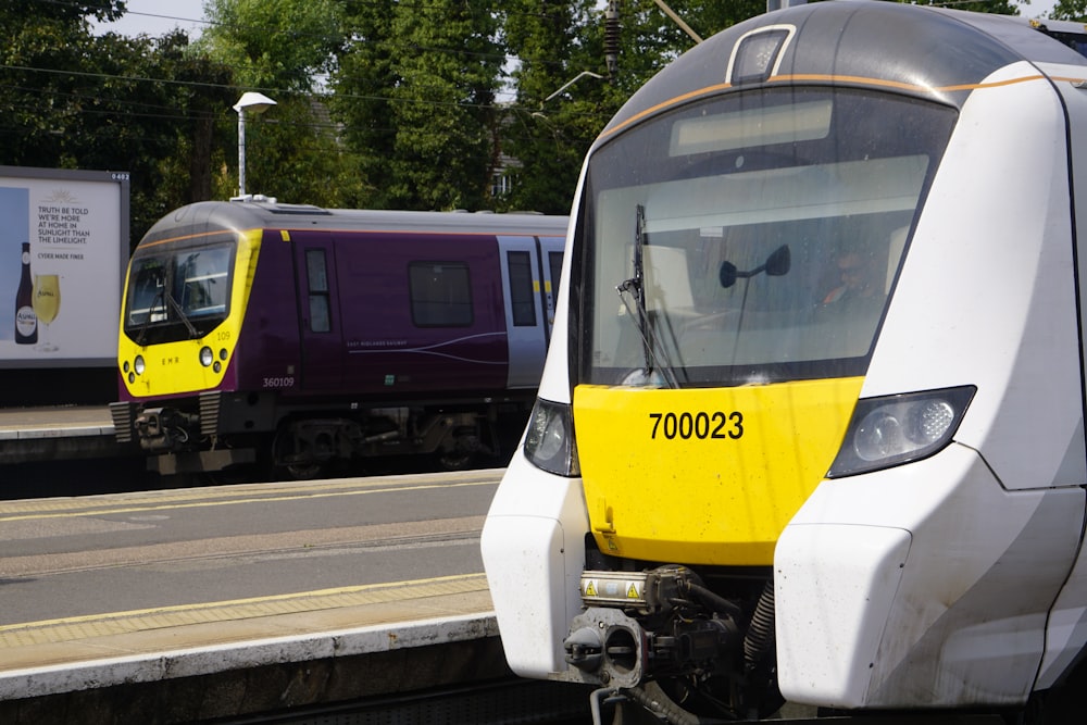 um trem amarelo e branco viajando pelos trilhos do trem