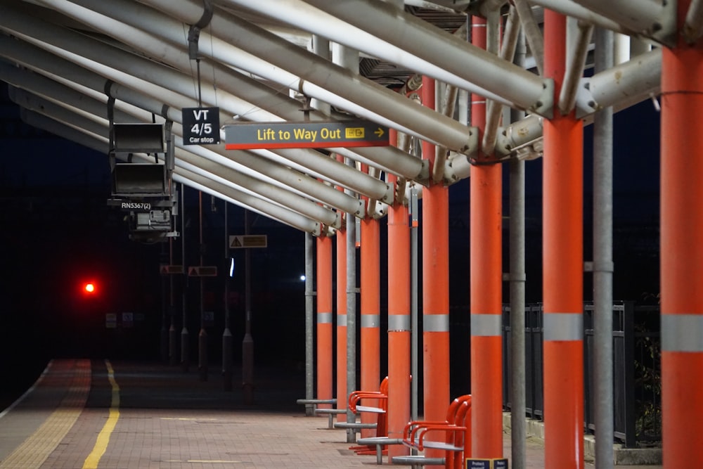 una estación de tren con una luz roja al final de la plataforma