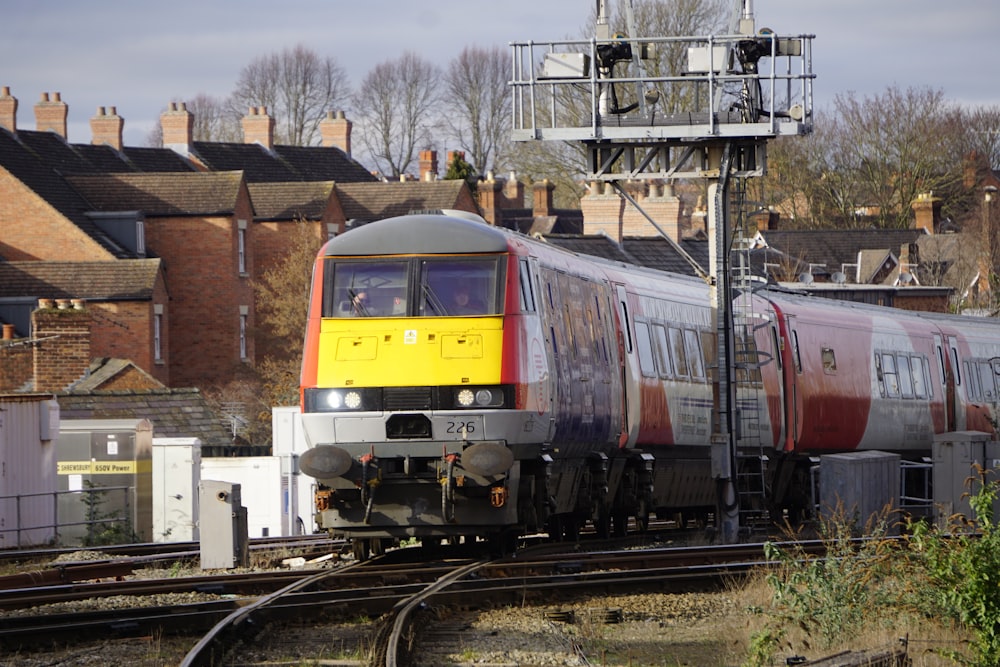 a yellow and red train traveling down train tracks