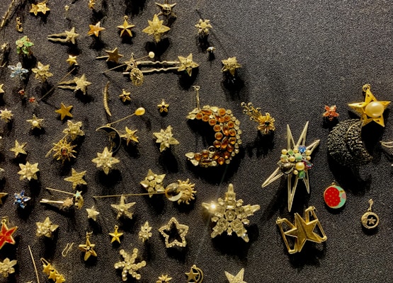 A variety of small gift items including pins, keychains, and badges arranged on a rustic wooden surface.