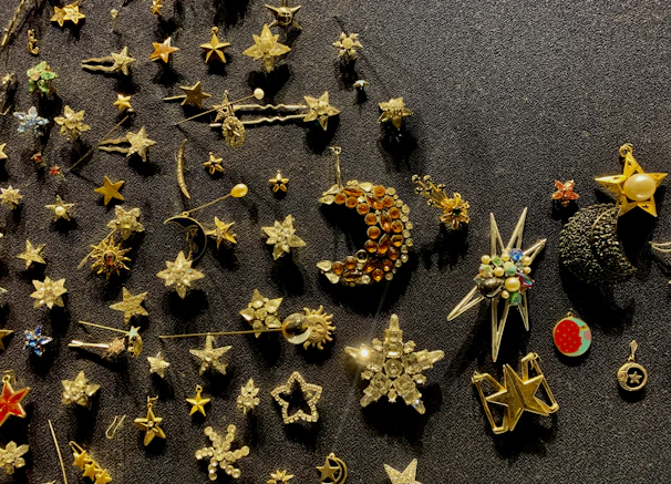 Close-up of a glittering Disney pin collection arranged on a blush pink background with subtle sparkle accents.