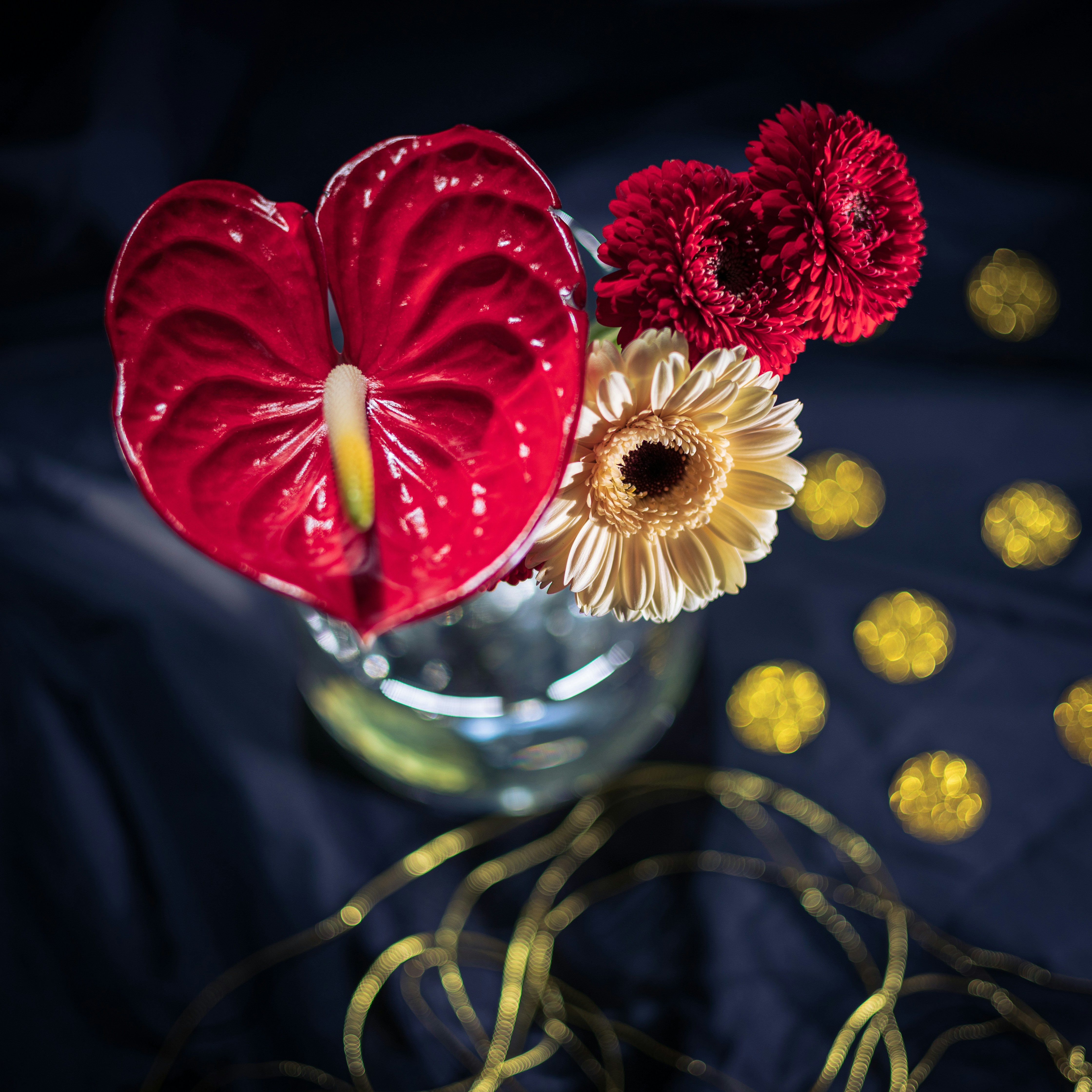 花が入った赤いハート型の花瓶