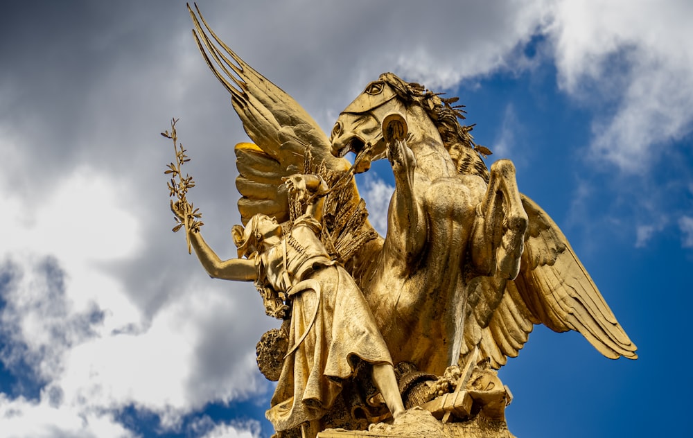 a golden statue of an angel holding a plant