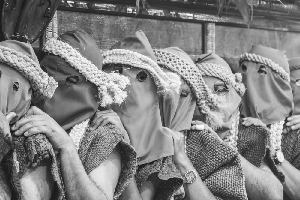 a group of people wearing head coverings sitting next to each other