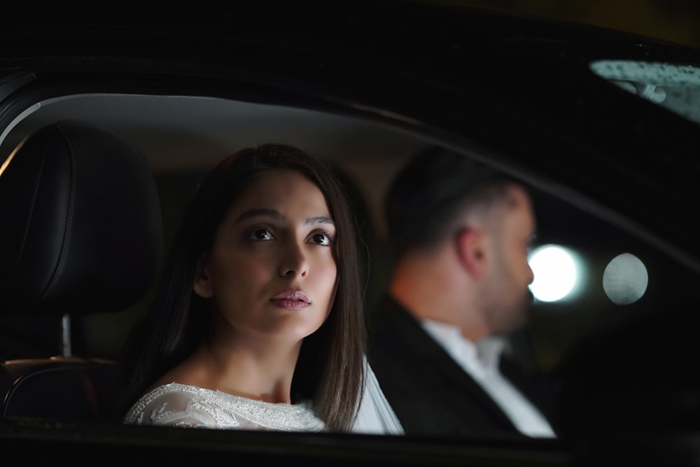 a man and a woman sitting in a car