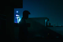 A silhouette of a person standing strong amid a dimly lit urban landscape.