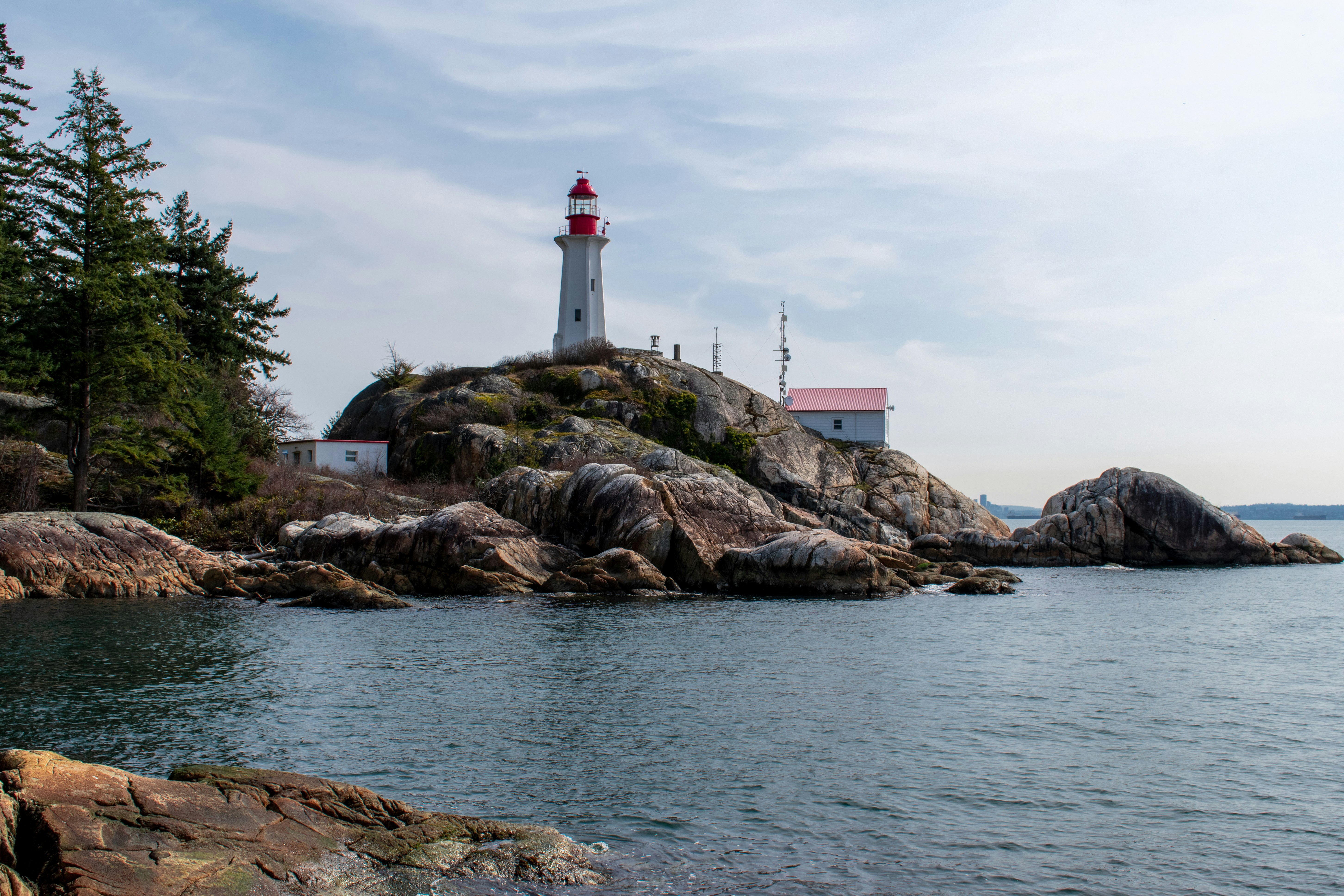 Lighthouse Park in Vancouver, Canada, featuring a red lighthouse on a rocky cliff overlooking the ocean. Photo by Daulet Turubayev on Unsplash.
