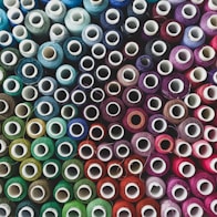 a pile of spools of different colors of thread