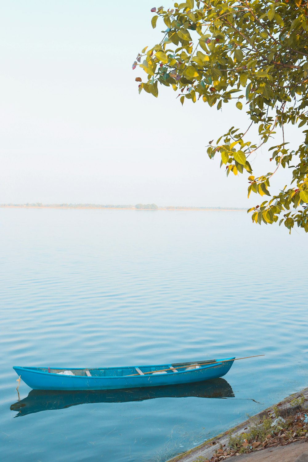 a small blue boat floating on top of a lake