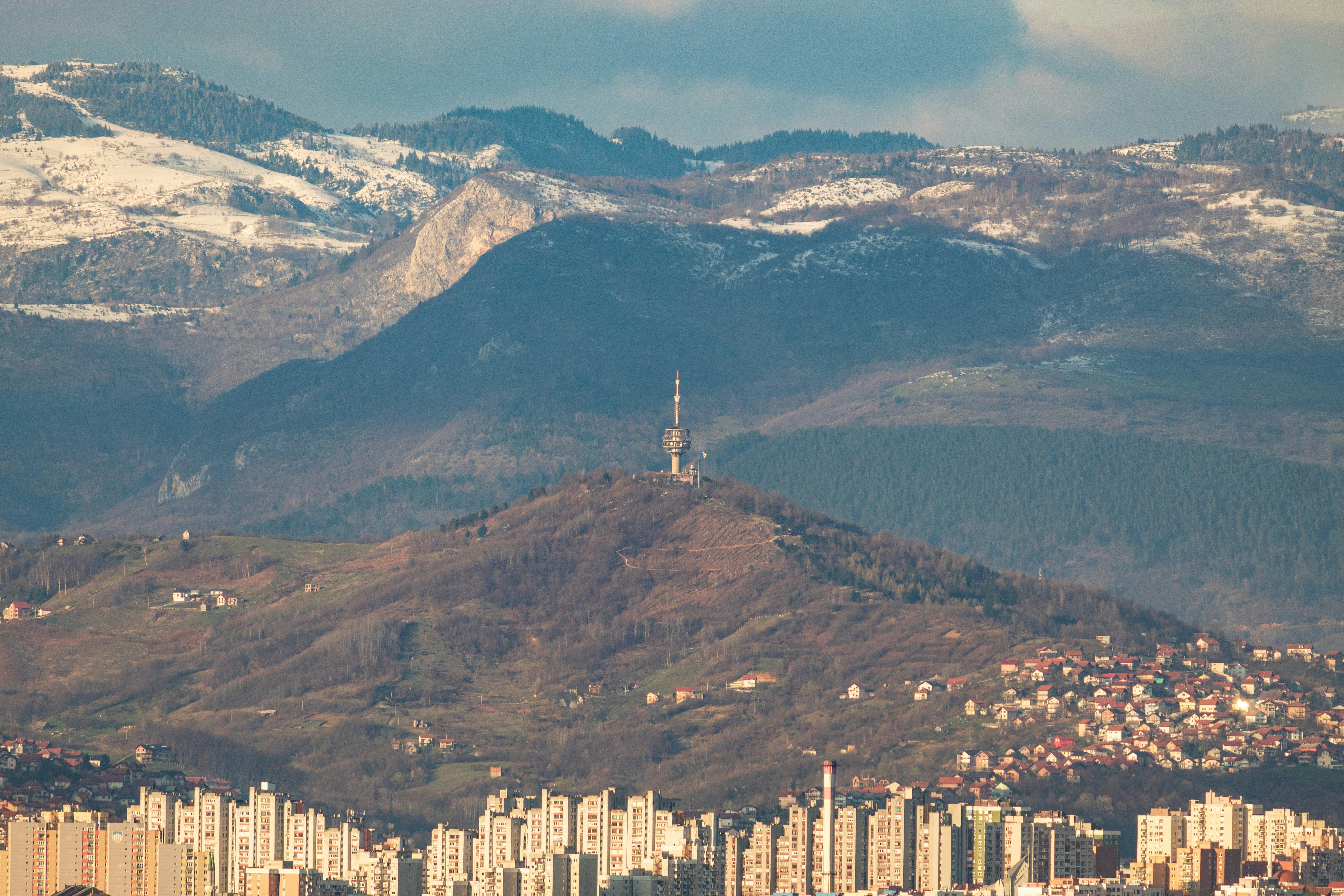 a view of a city with mountains in the background, 