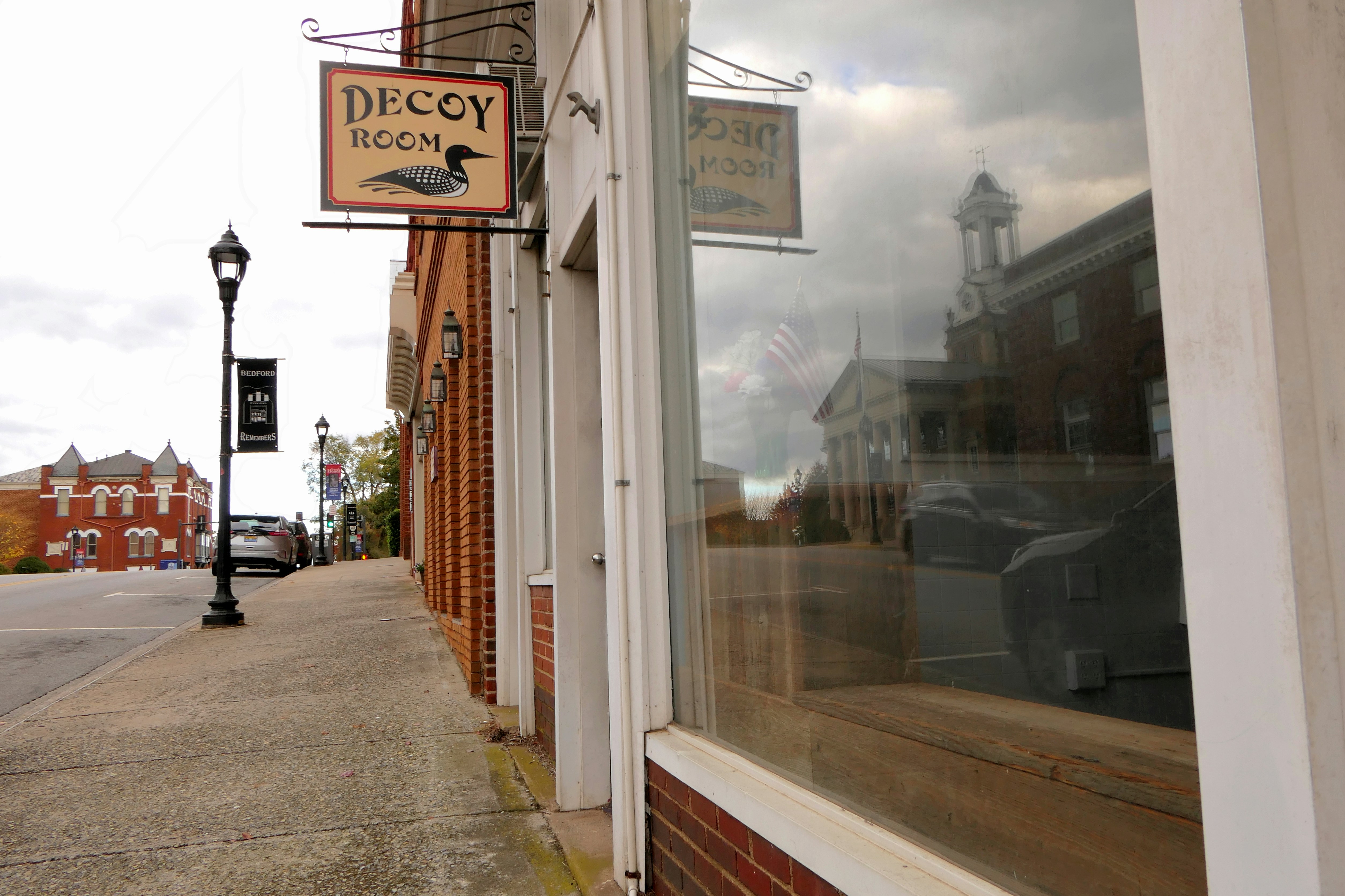 a store front with a clock tower in the background