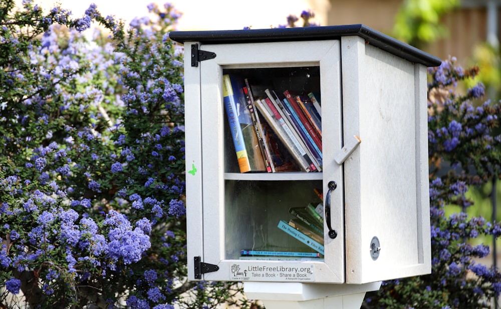 uma caixa de correio branca com um monte de livros nela