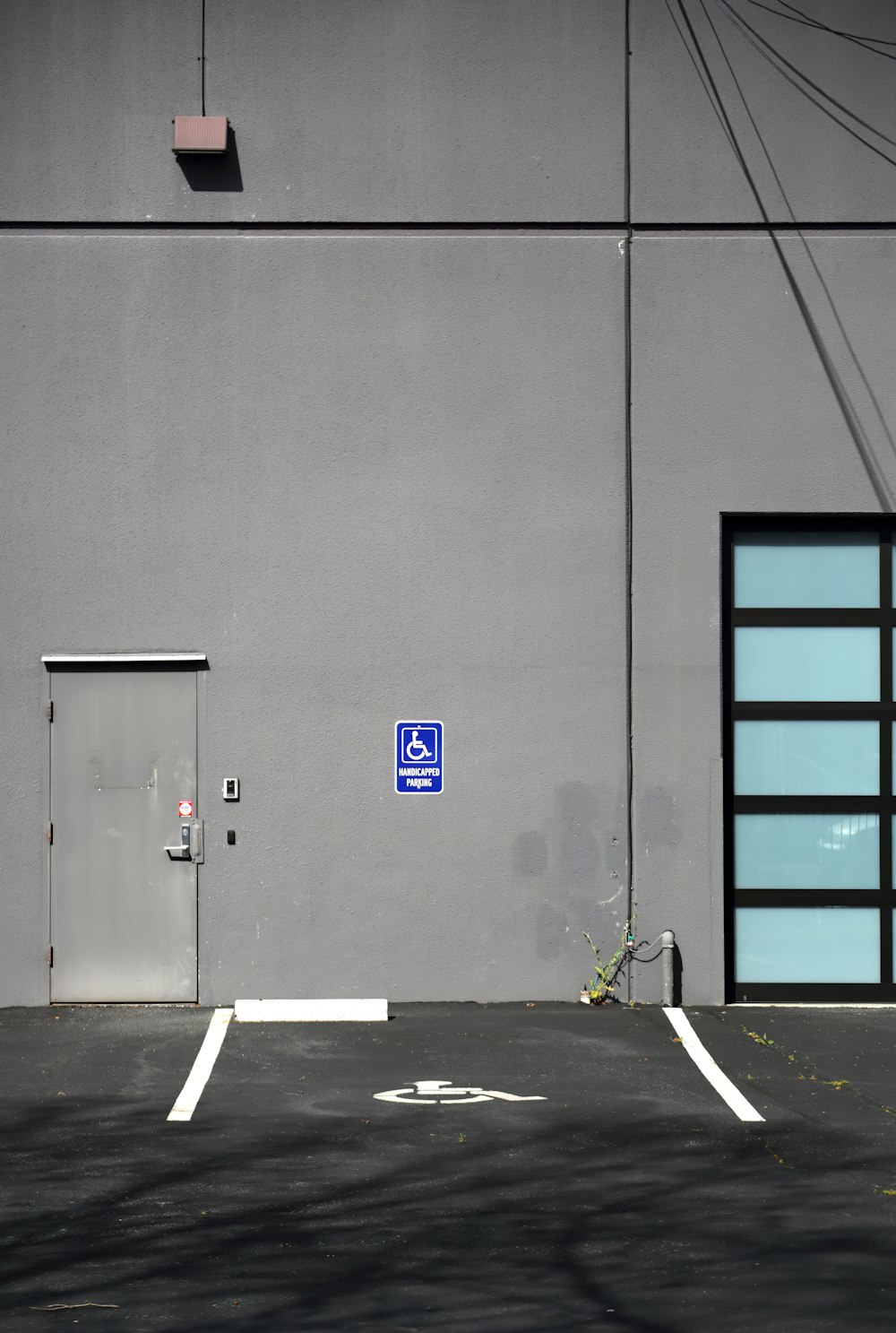 an empty parking lot with a blue sign on the side of a building