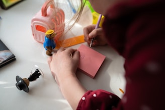 A designer sketching colorful toy concepts on a drawing pad in a bright studio.
