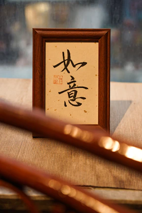 Close-up of a gold-finished CNC calligraphy frame glowing softly against a cream parchment background.