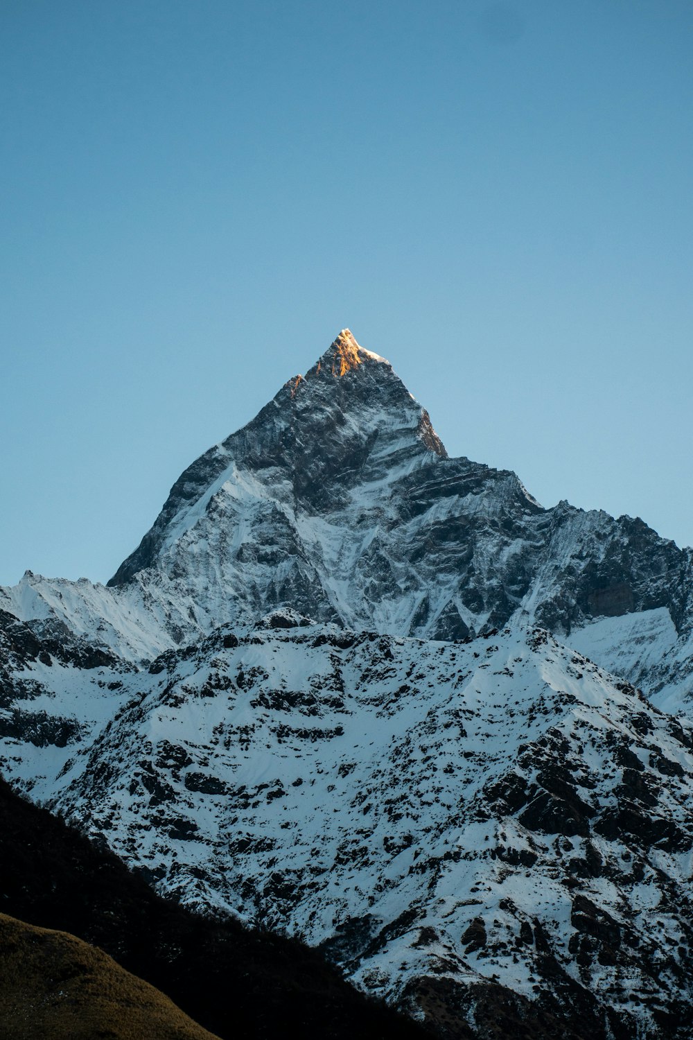 Una montaña cubierta de nieve con un cielo azul claro