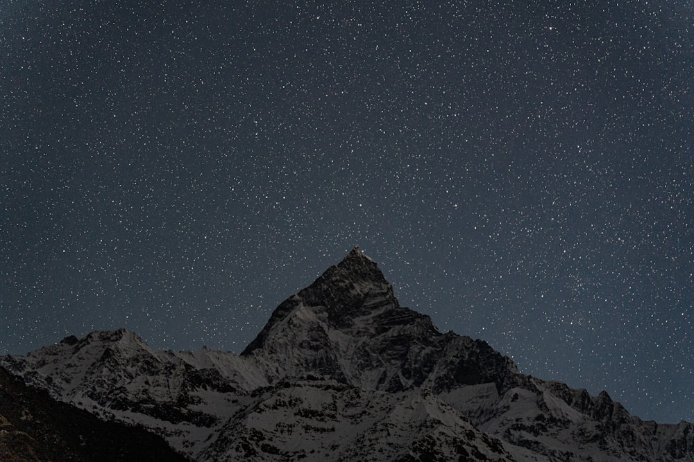 o céu noturno com estrelas acima de uma montanha