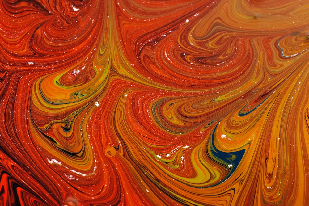 a close up of a red, yellow, and blue swirled background