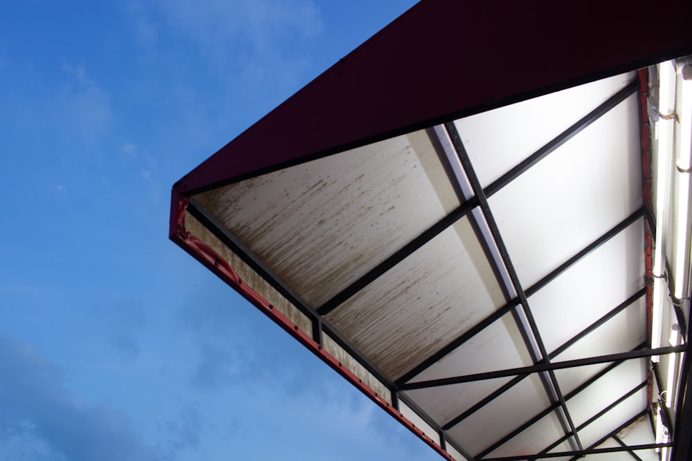 a red and white awning against a blue sky