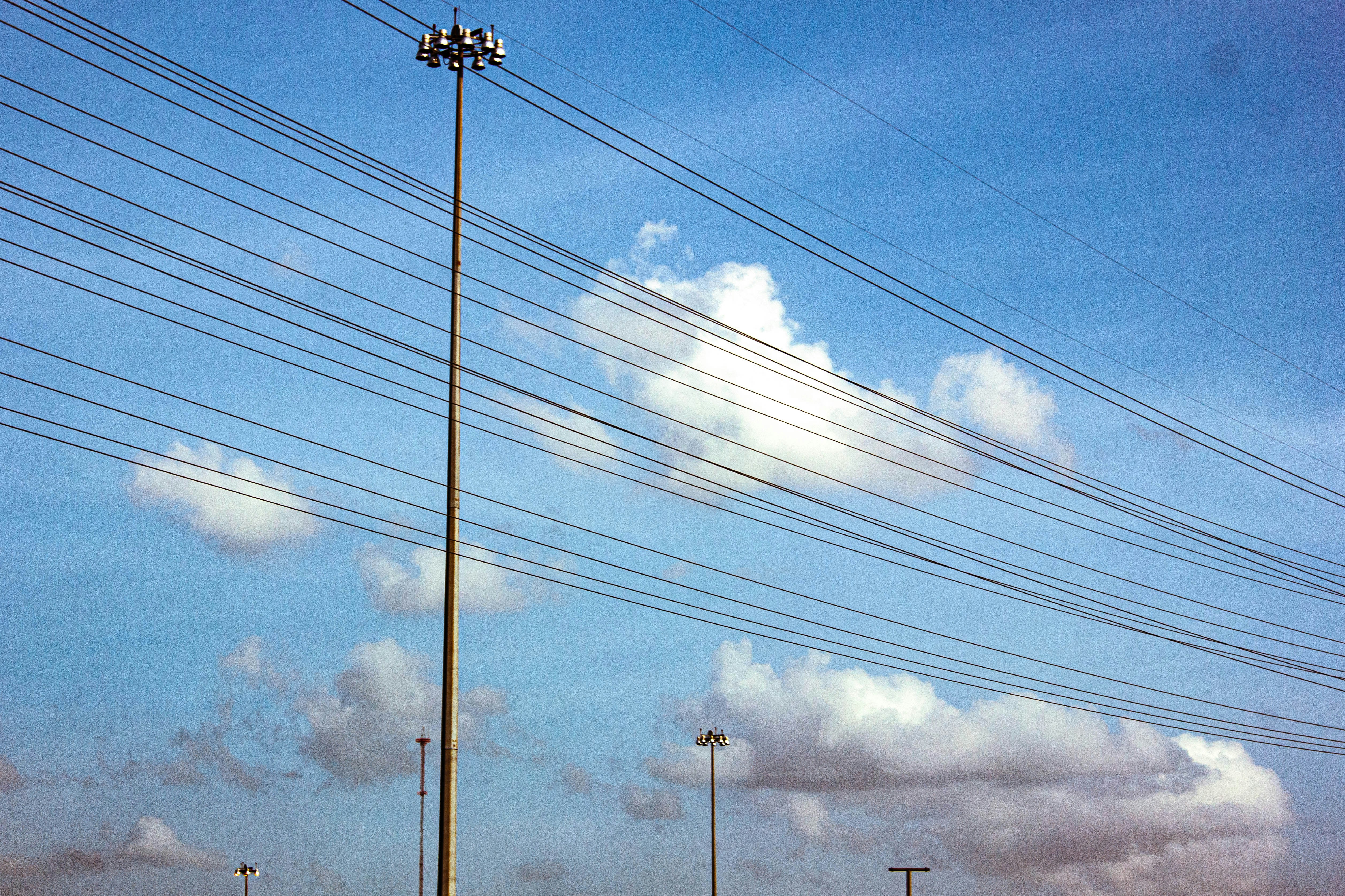 A row of telephone poles sitting on the side of a road photo – Free
