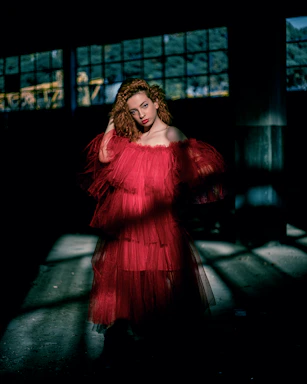 Curvy woman confidently wearing a flowing elegant dress in a bright, modern setting