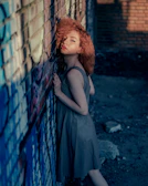 Golden hour portrait of a man leaning against a graffiti wall, capturing urban vibes.