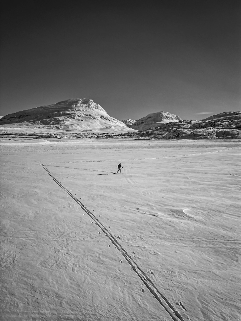 eine Person, die über ein schneebedecktes Feld fährt