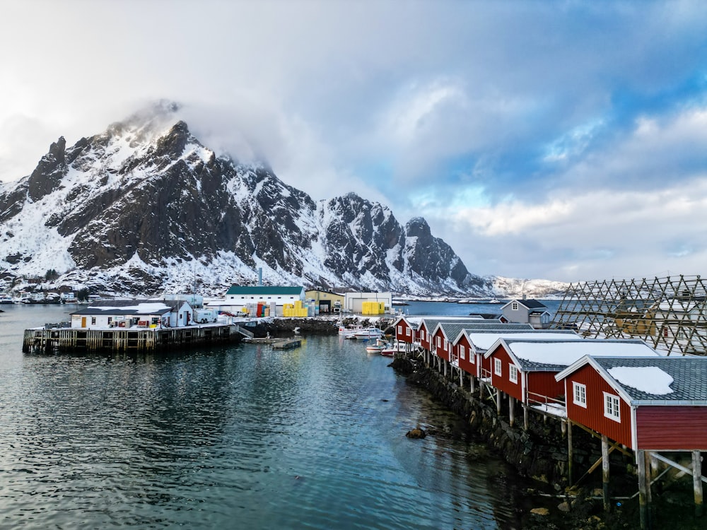 a group of red houses sitting on top of a body of water