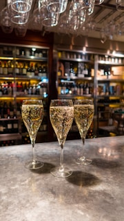 three wine glasses sitting on top of a counter