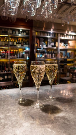 three wine glasses sitting on top of a counter
