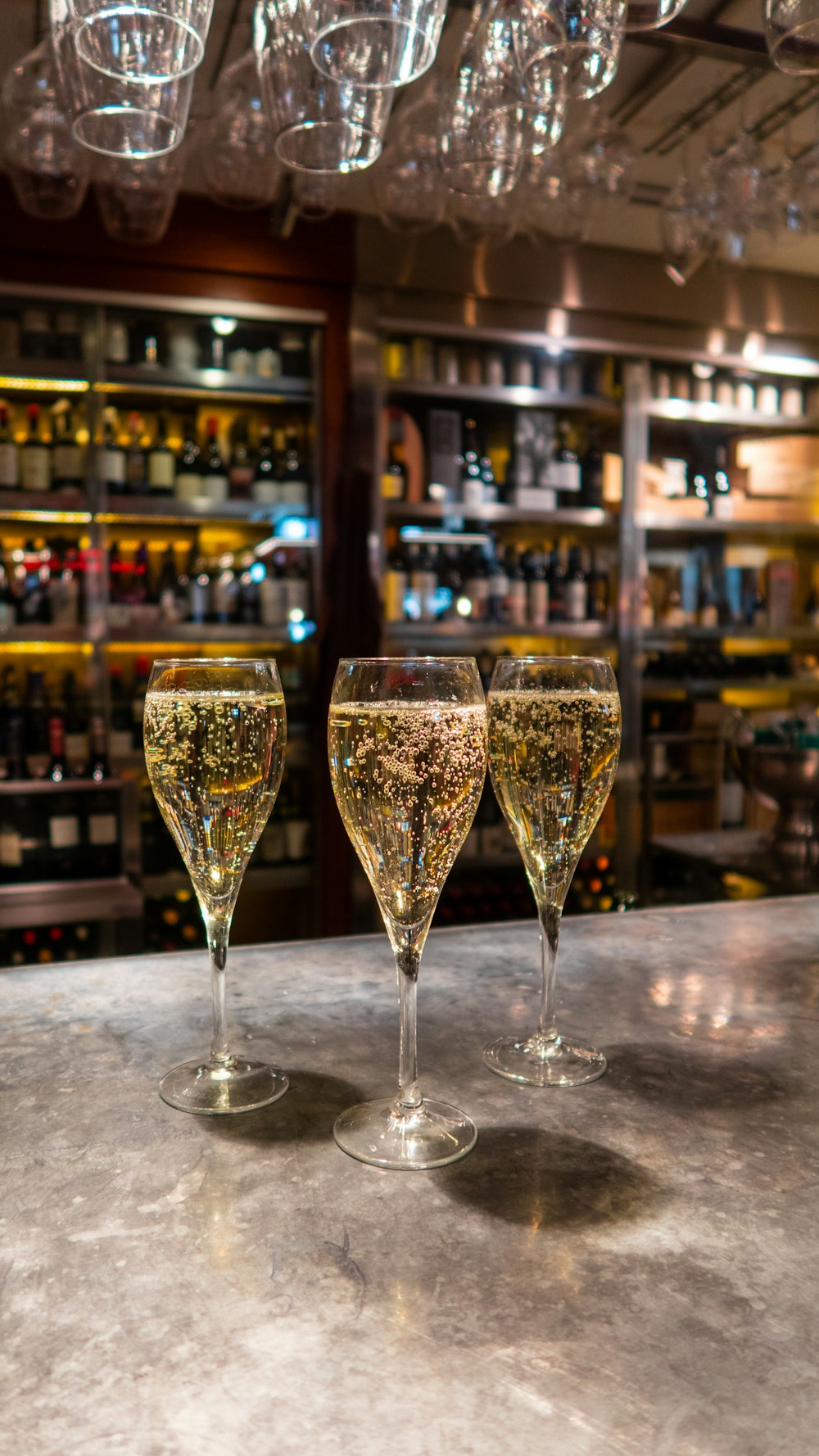 three wine glasses sitting on top of a counter