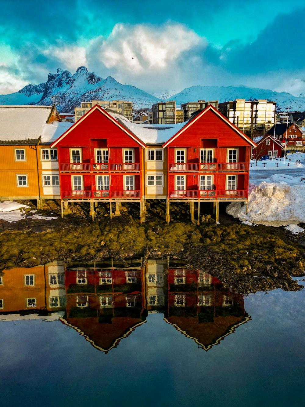 a group of red buildings sitting next to a body of water
