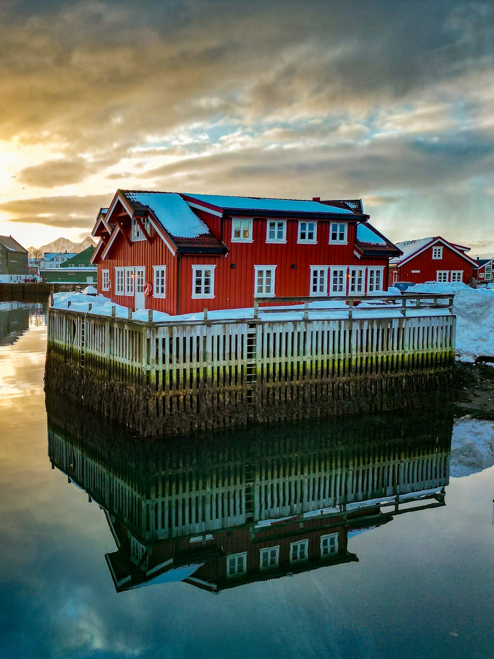 a red house sitting on top of a body of water