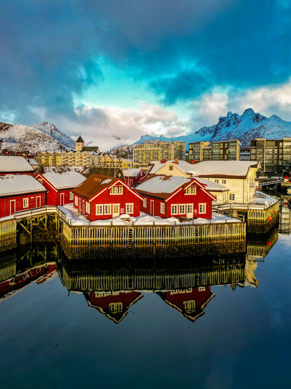 a group of red buildings sitting next to a body of water