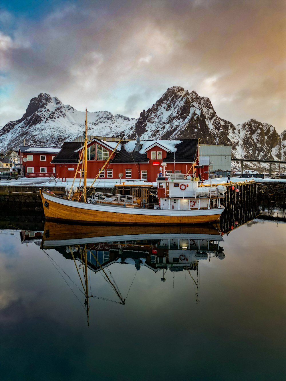 a boat is docked in a harbor with mountains in the background