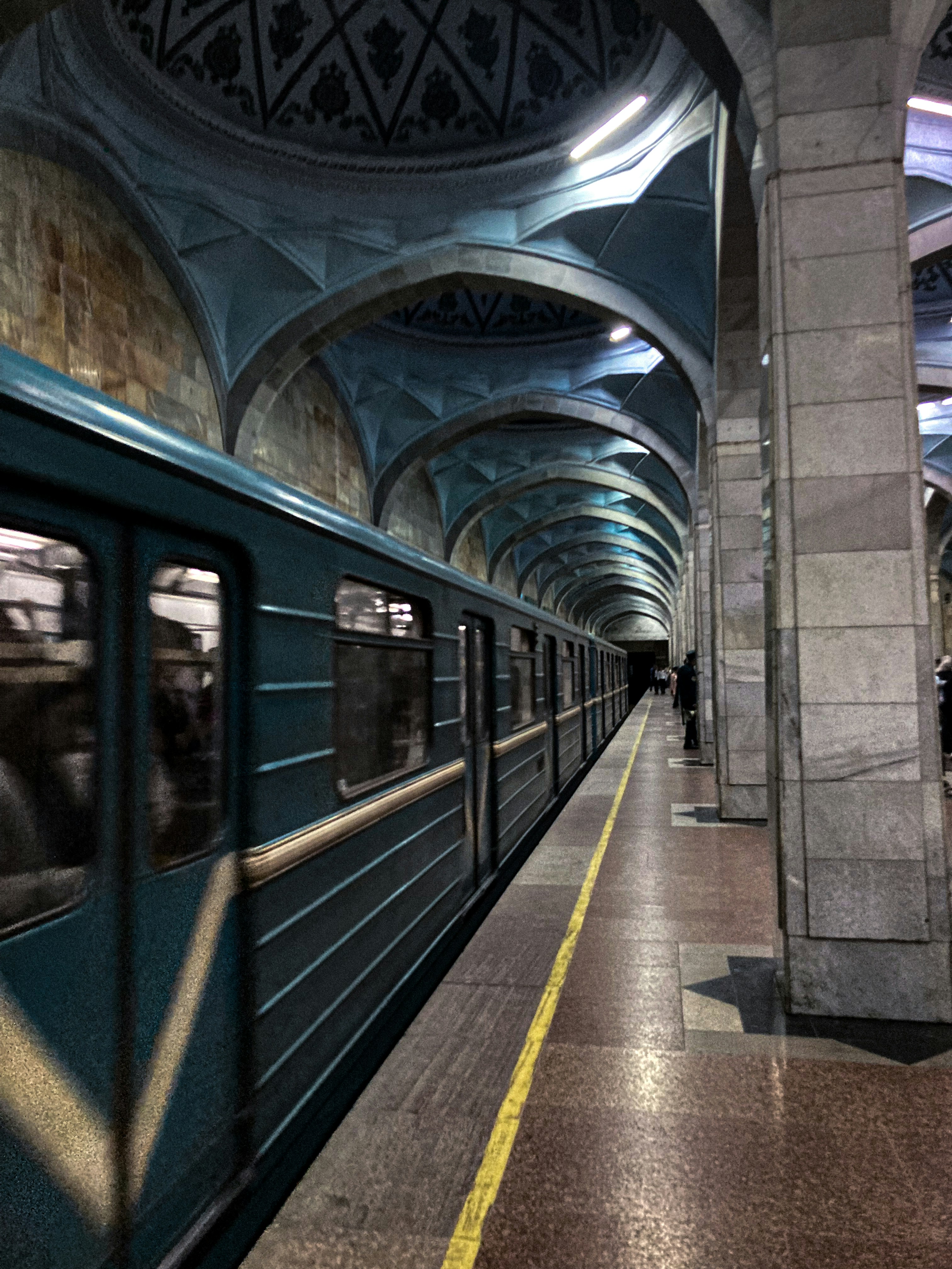 A train traveling through a train station next to a platform