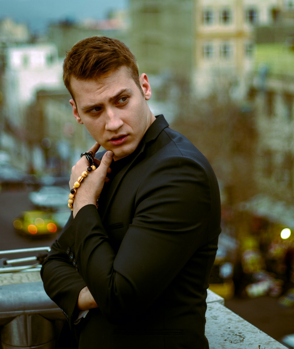 a man in a black shirt leaning on a railing