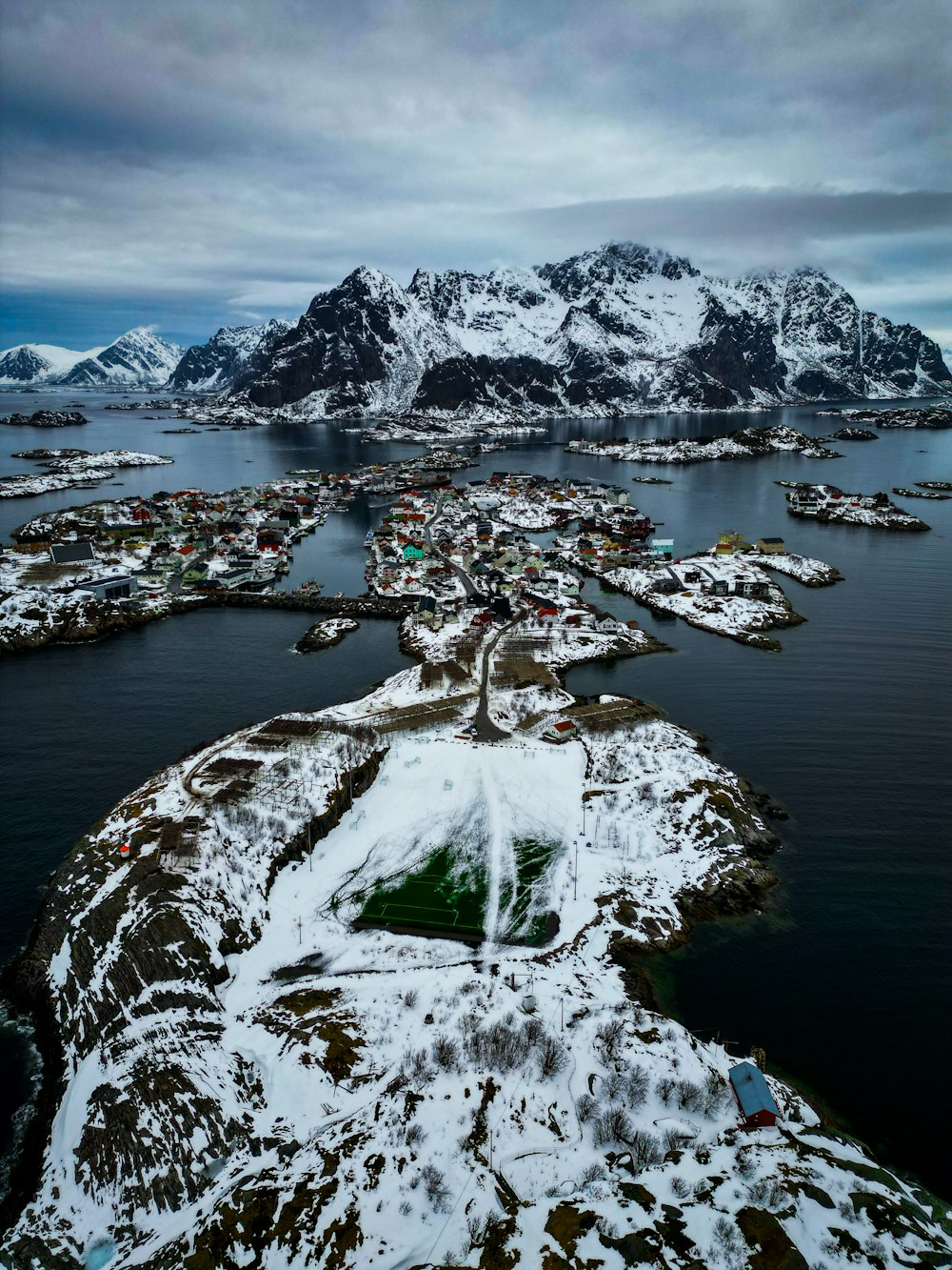 an aerial view of a small town surrounded by snow covered mountains