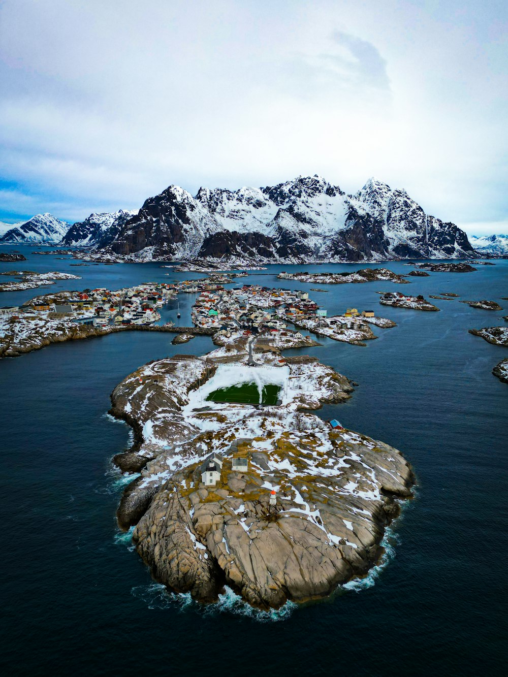 an aerial view of a snow covered island in the middle of the ocean