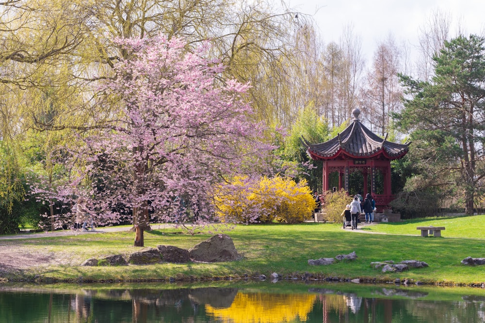 a gazebo in a park next to a lake