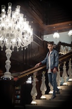 Professional cleaner carefully dusting a luxury estate’s elegant staircase with soft navy and gold accents.