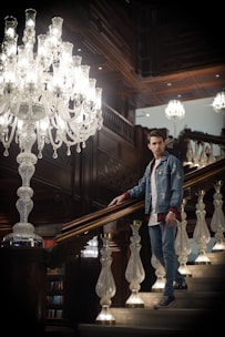 Professional cleaner carefully dusting a luxury estate’s elegant staircase with soft navy and gold accents.