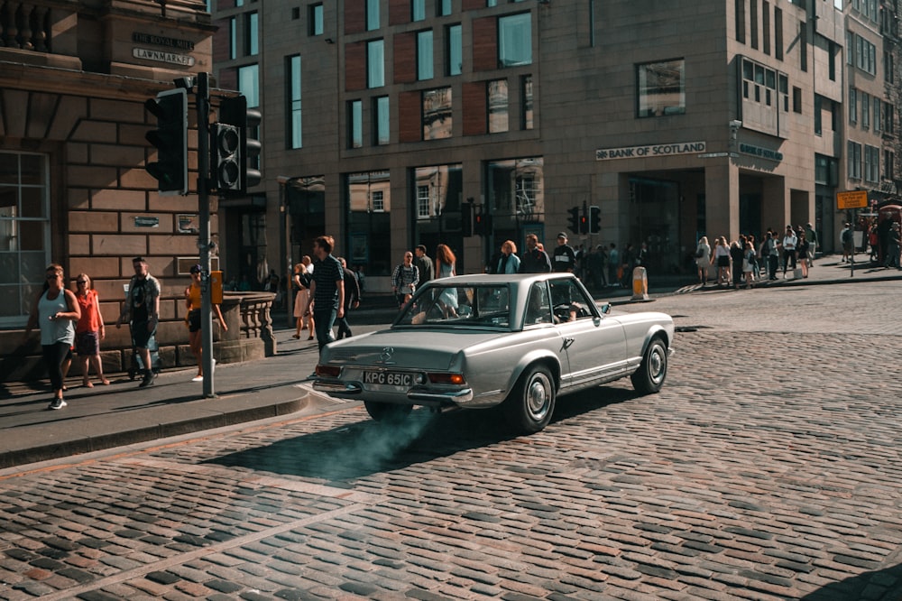 a car is driving down the street with a lot of people