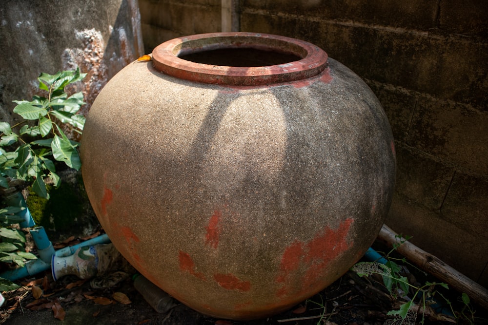 a large vase sitting on the ground next to a wall