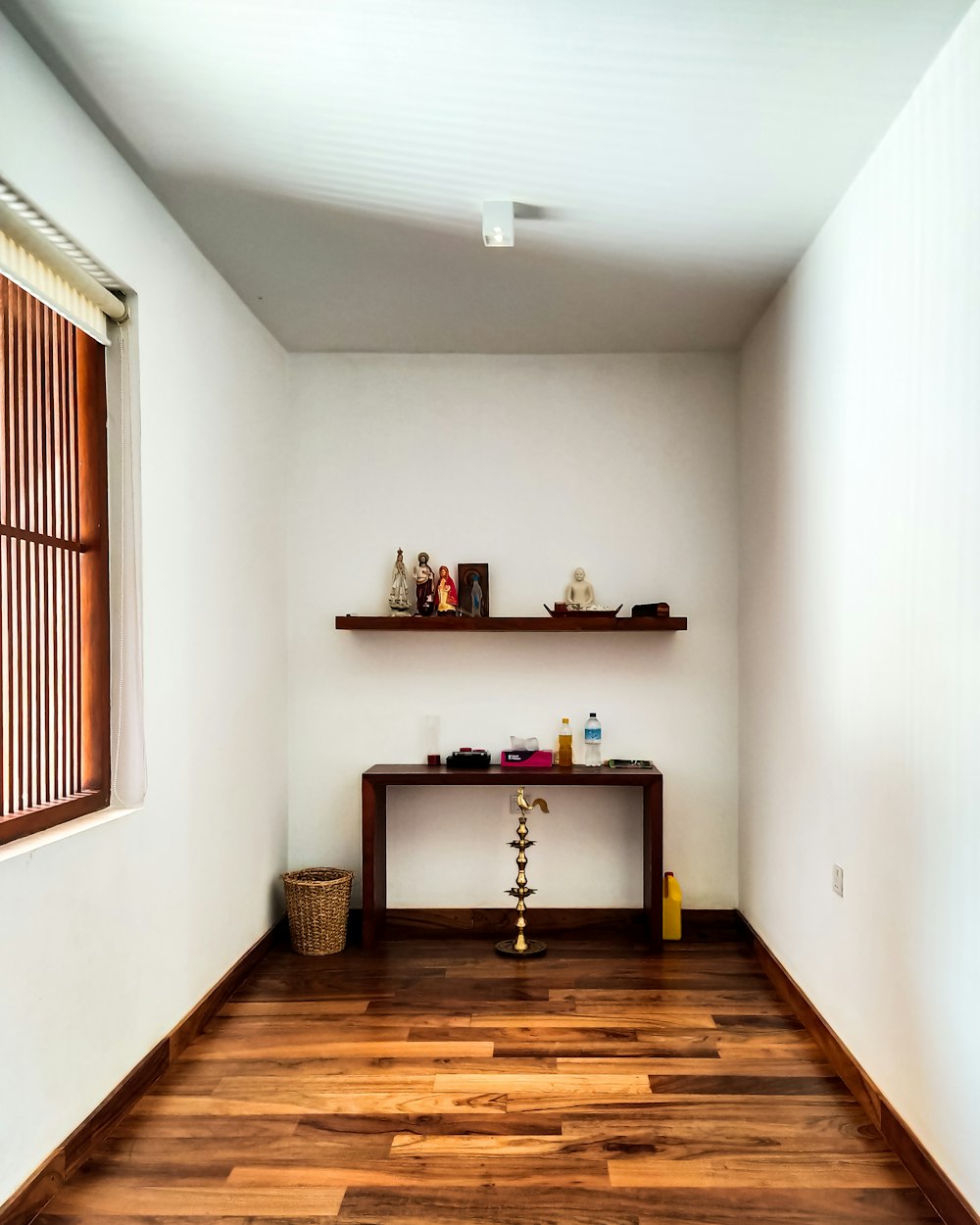 a room with a wooden floor and a shelf on the wall
