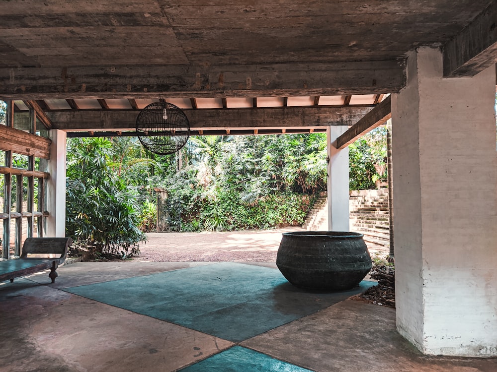 a large black pot sitting on top of a cement floor