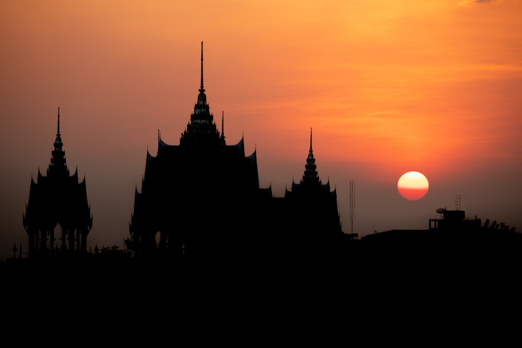 the sun is setting behind a building with spires